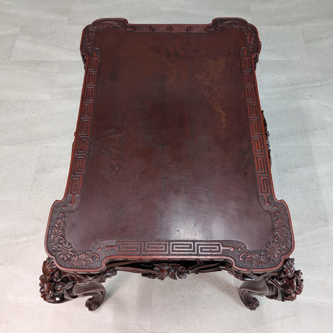 Overhead photograph of circa 1900 Meiji carved hardwood writing table showing Greek key border and age related marks on the tabletop