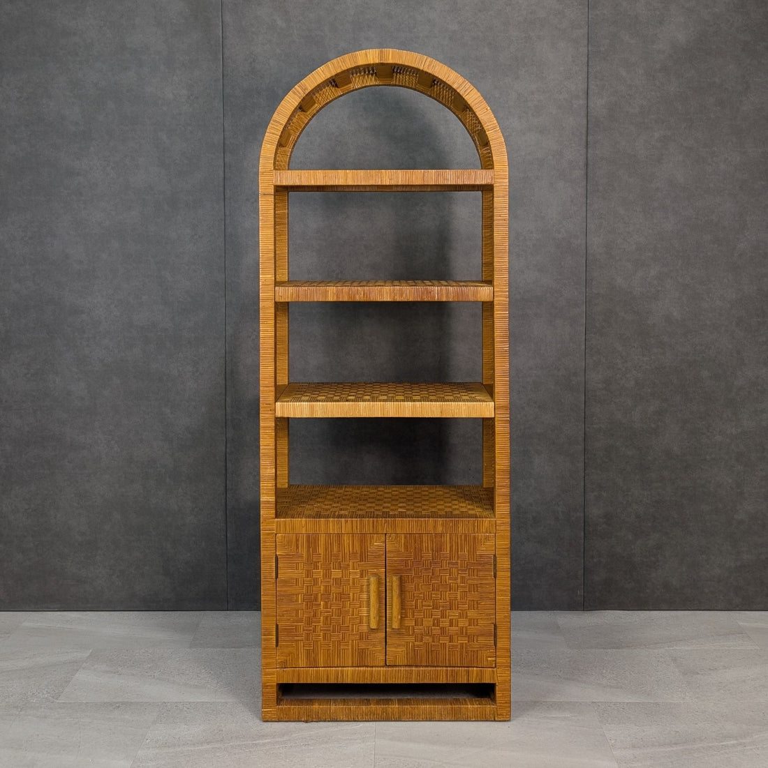 Front view of 1960s Danny Ho Fong style arched woven rattan bookcase with lower two door cupboard