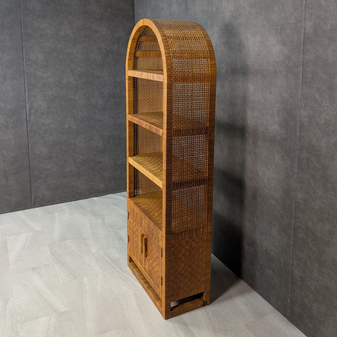 Tall mid century woven rattan bookcase in warm honey finish with open shelves and cupboard