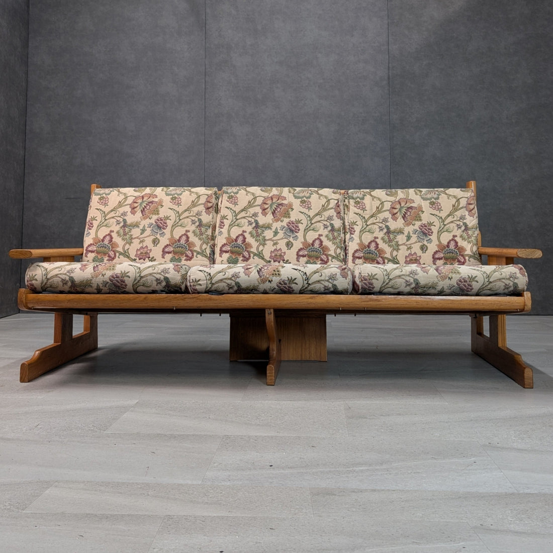 1970s Brutalist modernist New Guinea rosewood three seat lounge, front view with floral vintage cushions