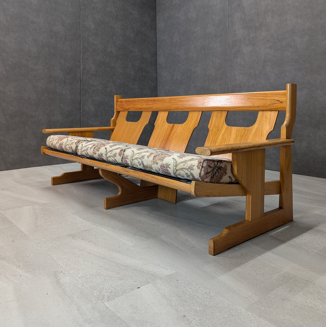Architectural rosewood three seat lounge angled view with vintage floral seat cushions and exposed timber back