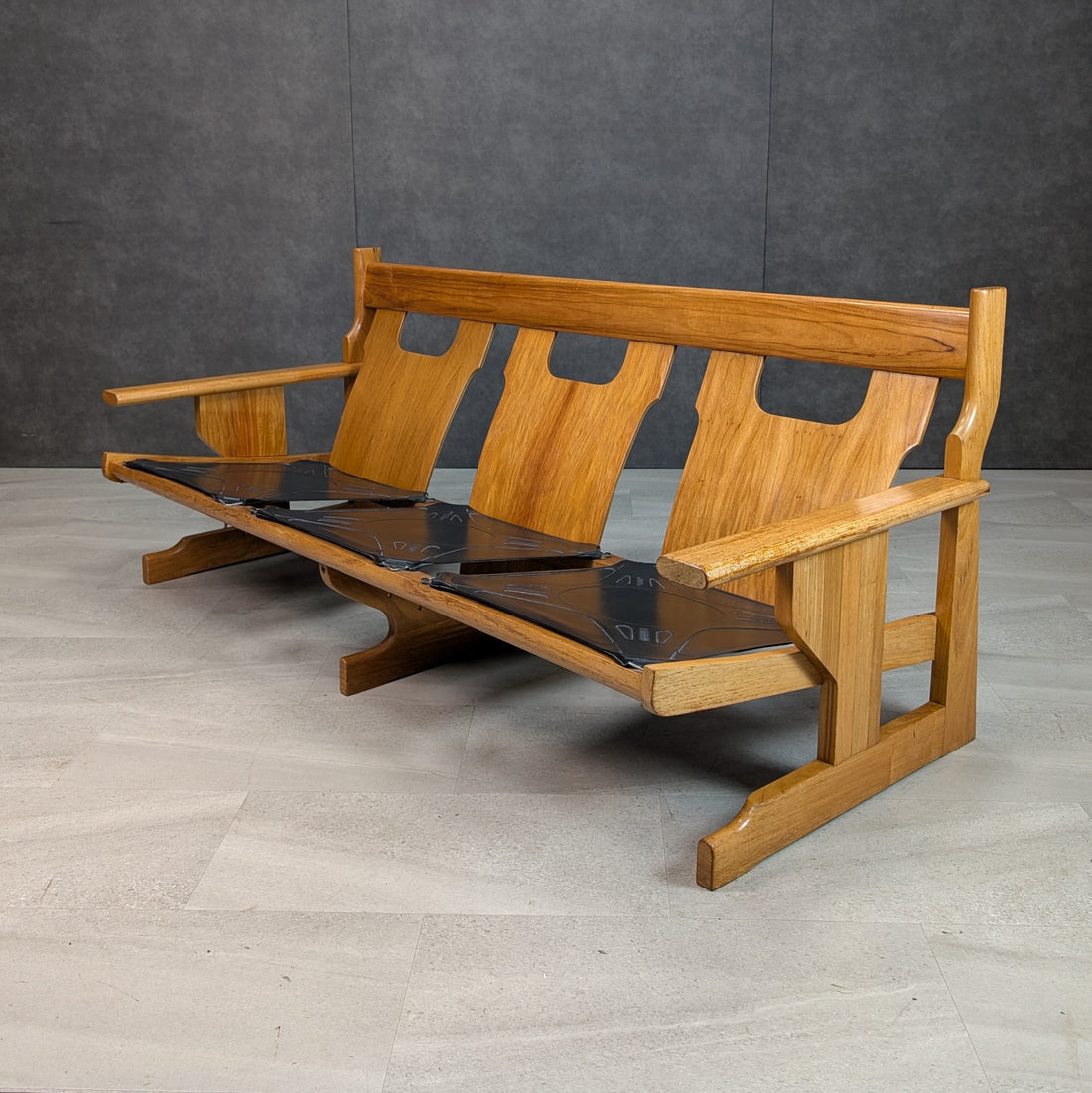 Three quarter front view of 1970s solid New Guinea rosewood modernist sofa frame and three seat supports