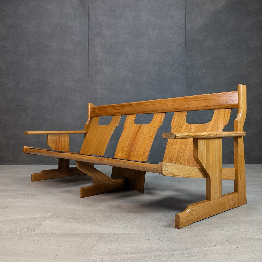 Rear angled view showing solid rosewood back panels, shaped arm supports and architectural timber legs