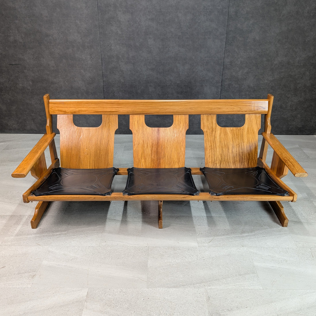 Direct front view of solid timber three seat modernist lounge without loose cushions