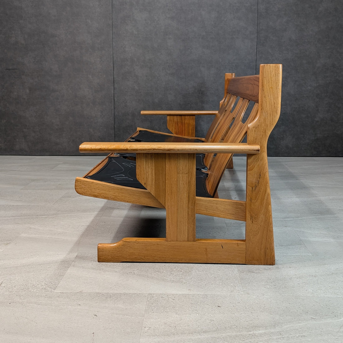 Profile of solid timber modernist three seat sofa with substantial shaped legs and horizontal armrests