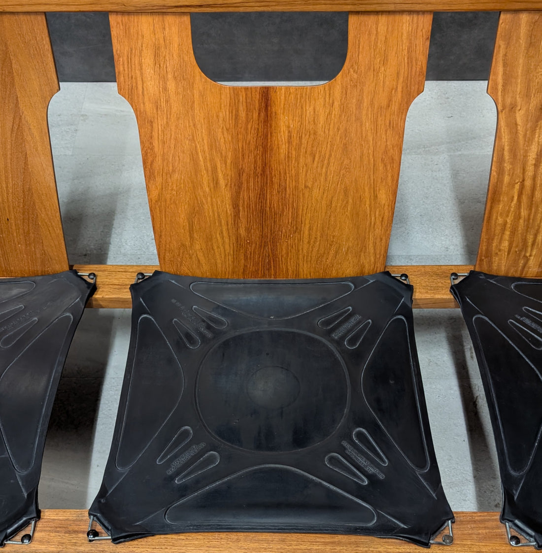 Close up of three black elastic seat support panels within the rosewood lounge frame