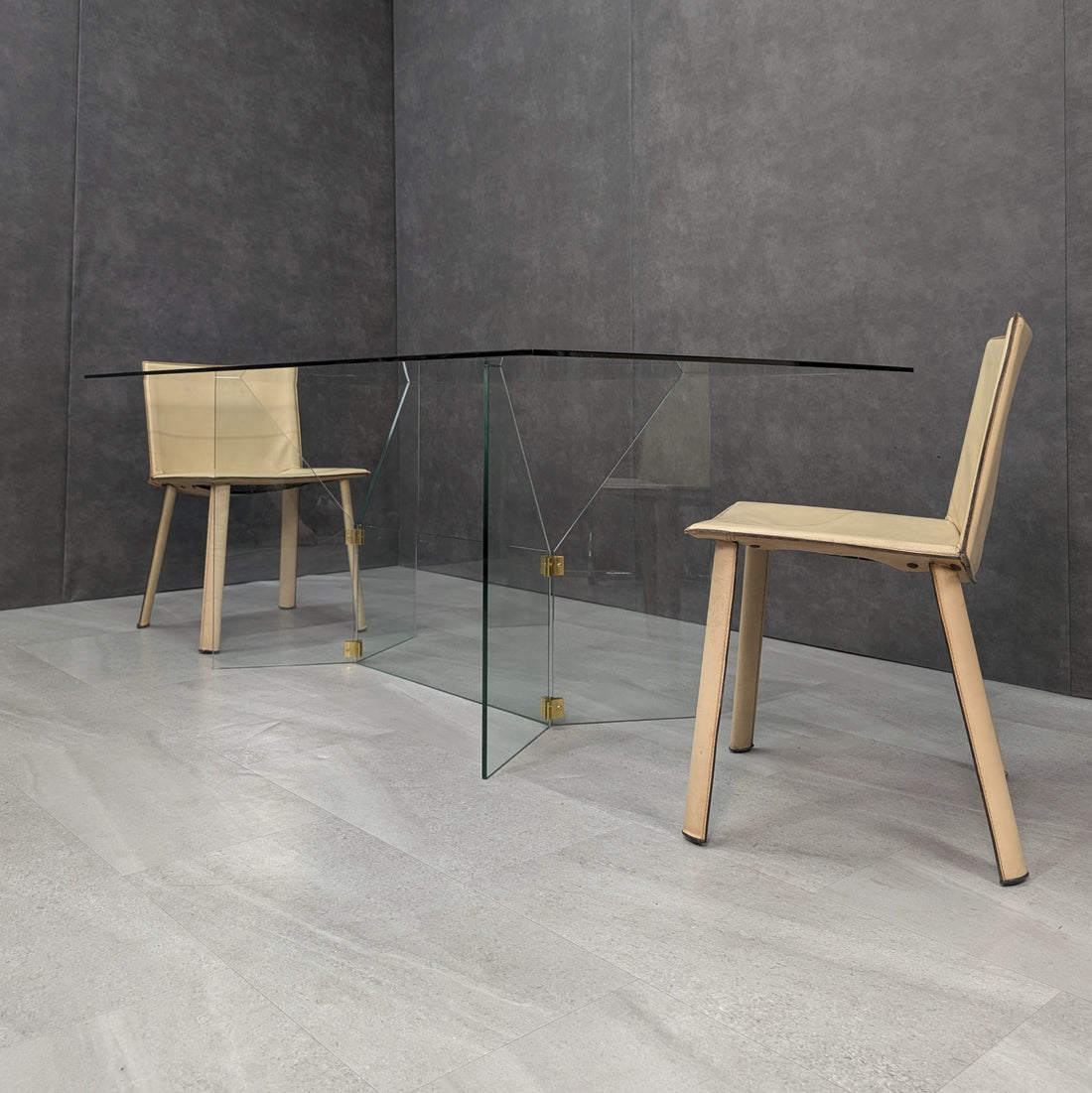 GRZ 2C clear glass dining table shown with two chairs for scale, angled view