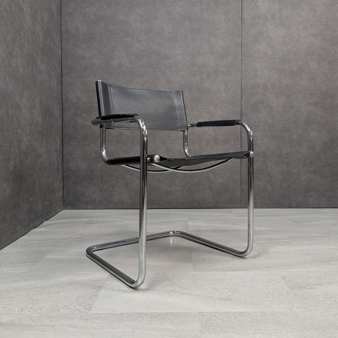Black leather and chrome cantilever armchairs showing the seat and arms