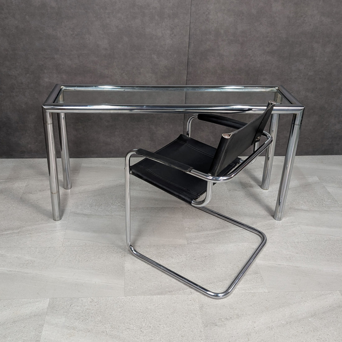 1970s tubular chrome and clear glass console table with black leather Bauhaus style cantilever armchair