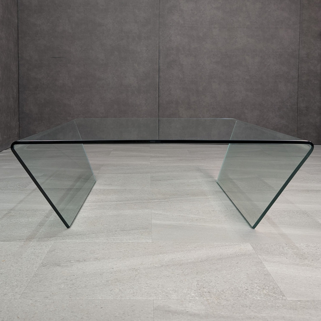 Front view of the square clear glass coffee table showing inward angled waterfall sides