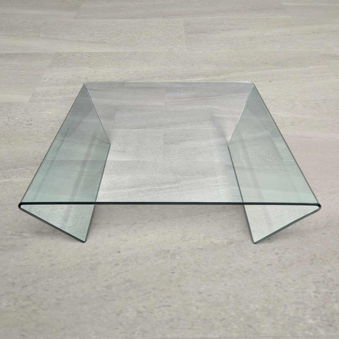 Elevated view of the clear bent glass coffee table showing the square top and seamless bends