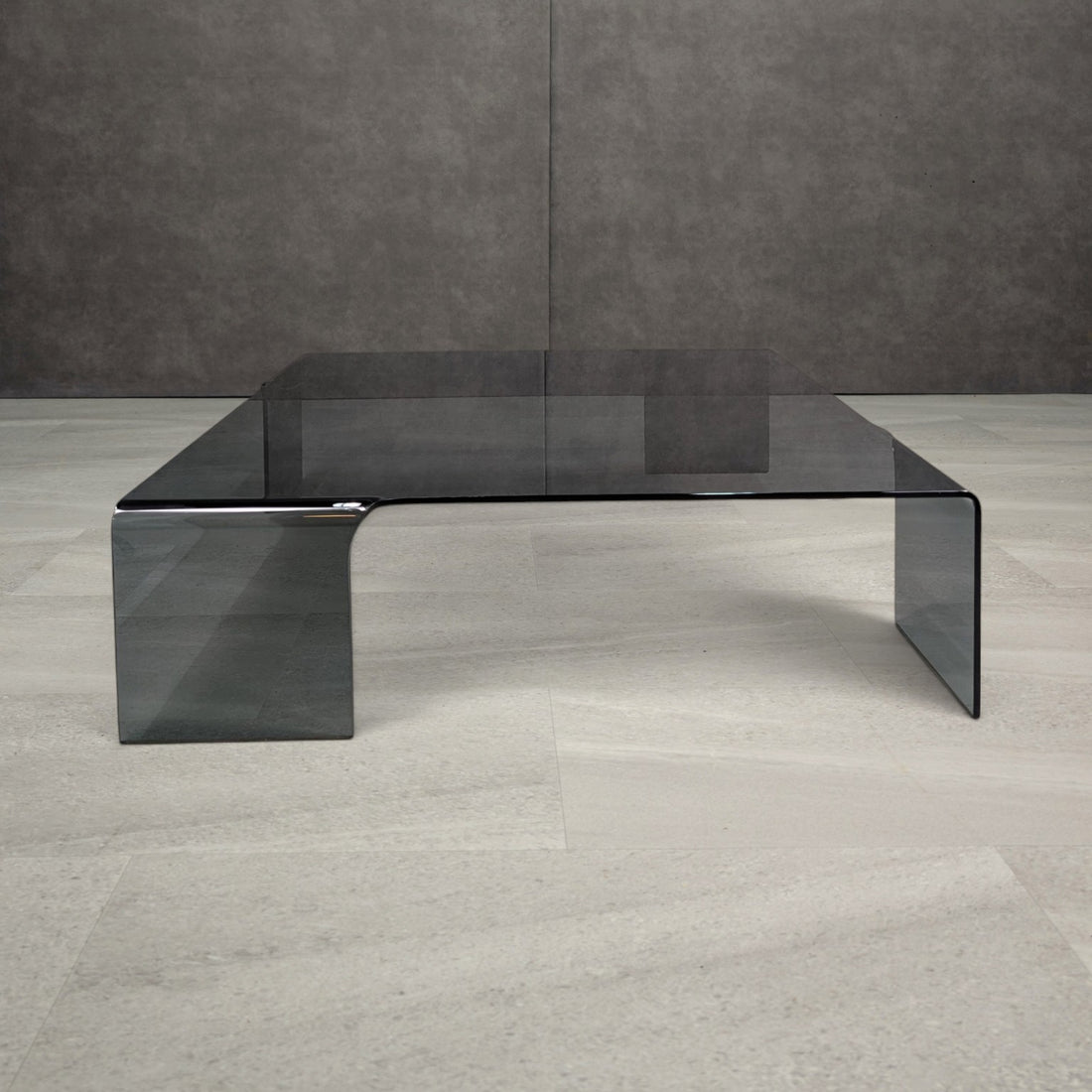 Front view of the smoked grey Neutra-style coffee table with smooth bent glass corners