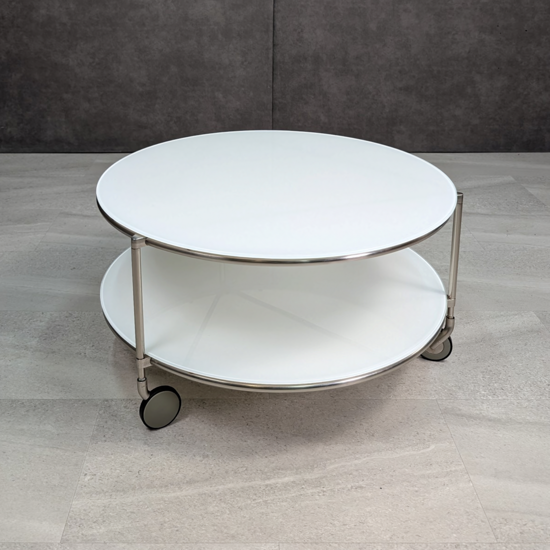 IKEA Strind round white glass coffee table with chrome frame and castors
