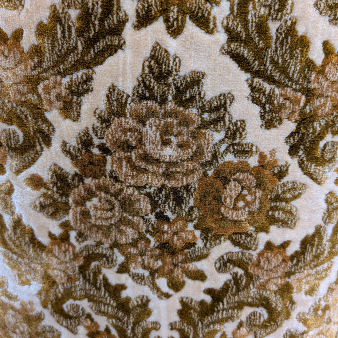 Detail of floral velvet upholstery in antique gold and olive