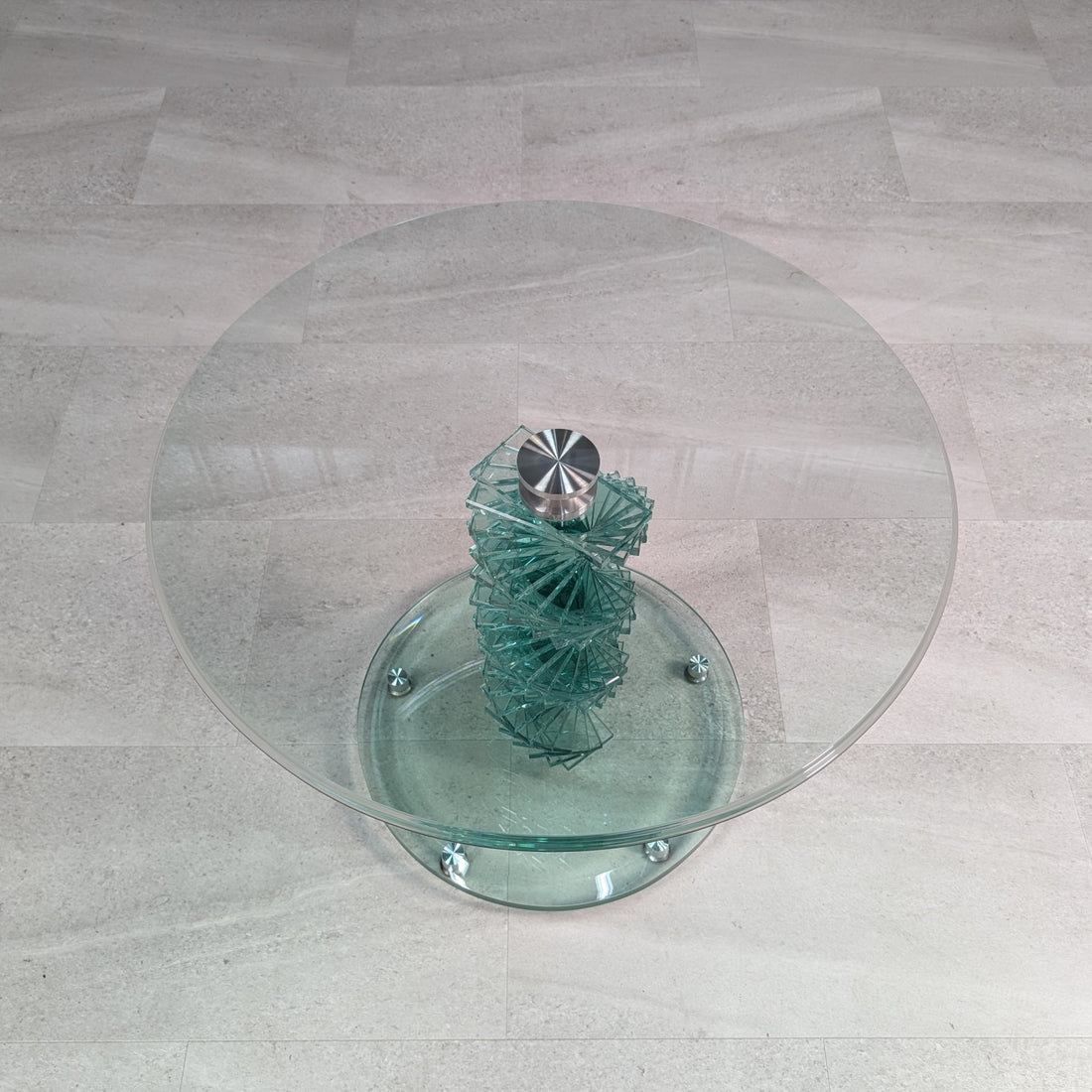 Overhead view of circular clear glass tabletop and layered glass helix pedestal