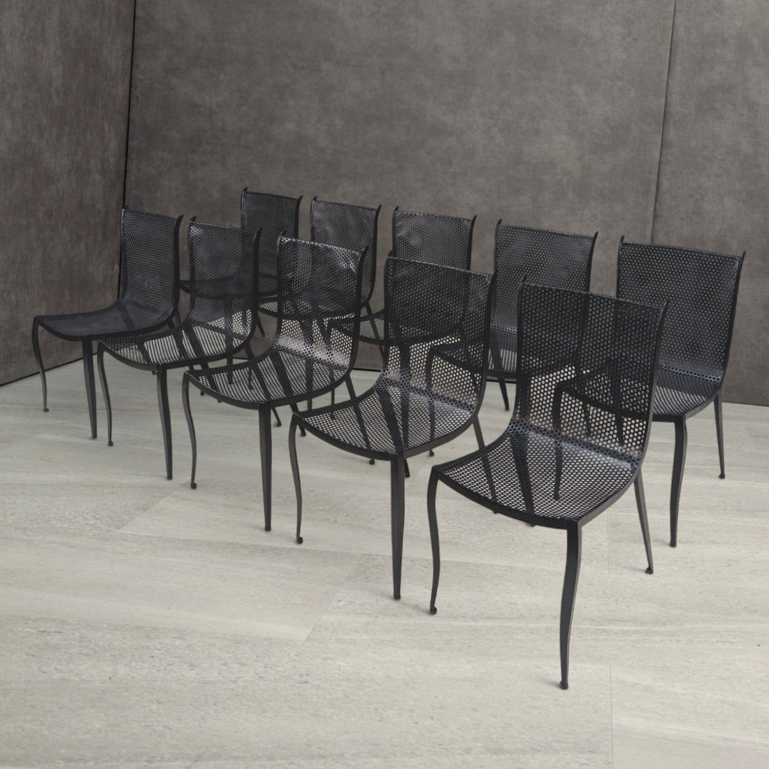 Vintage black perforated aluminium dining chairs with curved seats and slender tapering legs