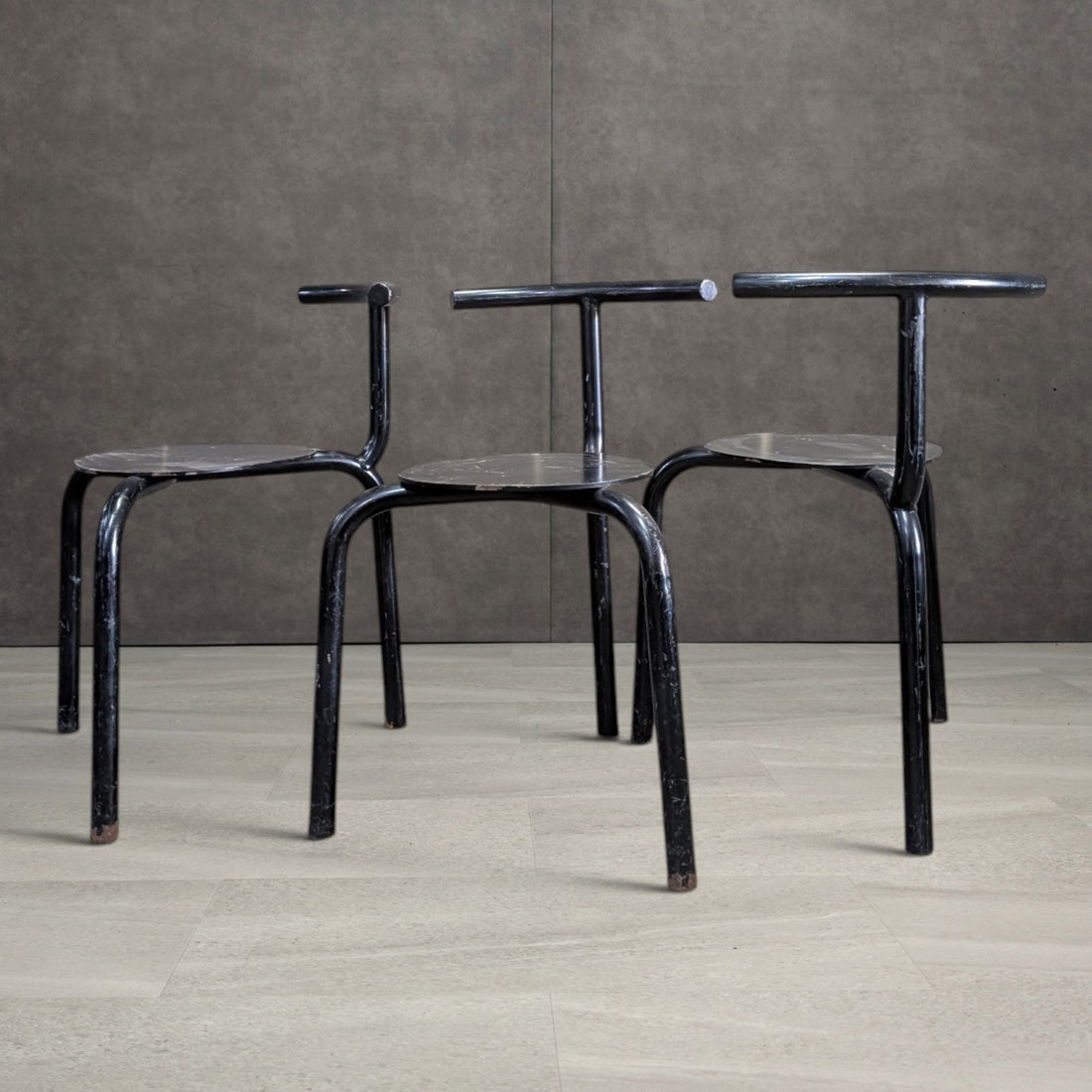 Group of vintage postmodern three leg tubular steel dining chairs, front view
