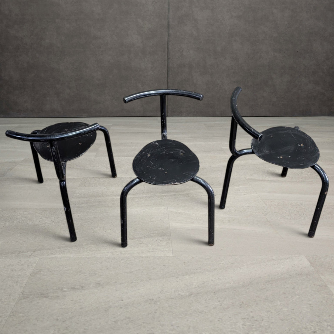 Three tubular steel chairs from above showing curved backs and circular steel seat plates