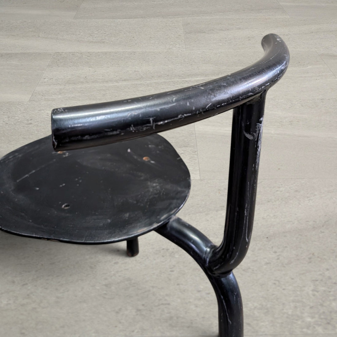 Side detail of heavy steel tube back support and unupholstered seat plate