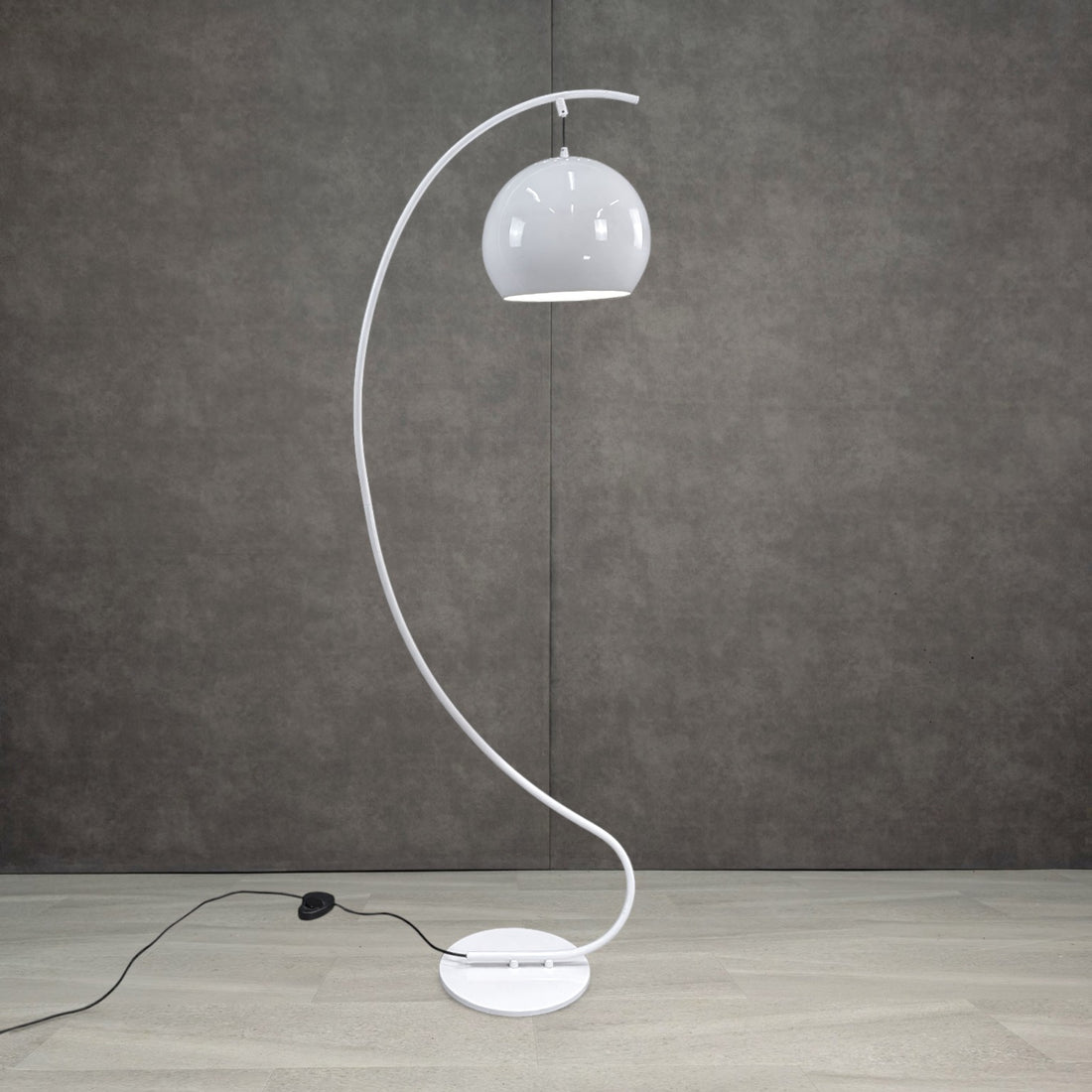 White sculptural S curve floor lamp from alternate front angle showing circular base