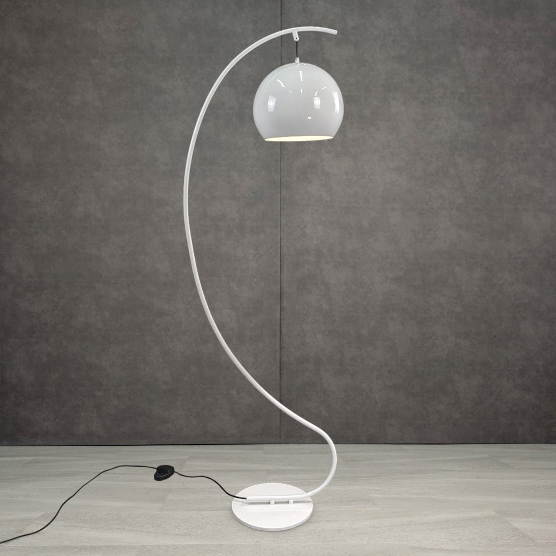 Vintage white enamel floor lamp illuminated showing dome shade and curved stand