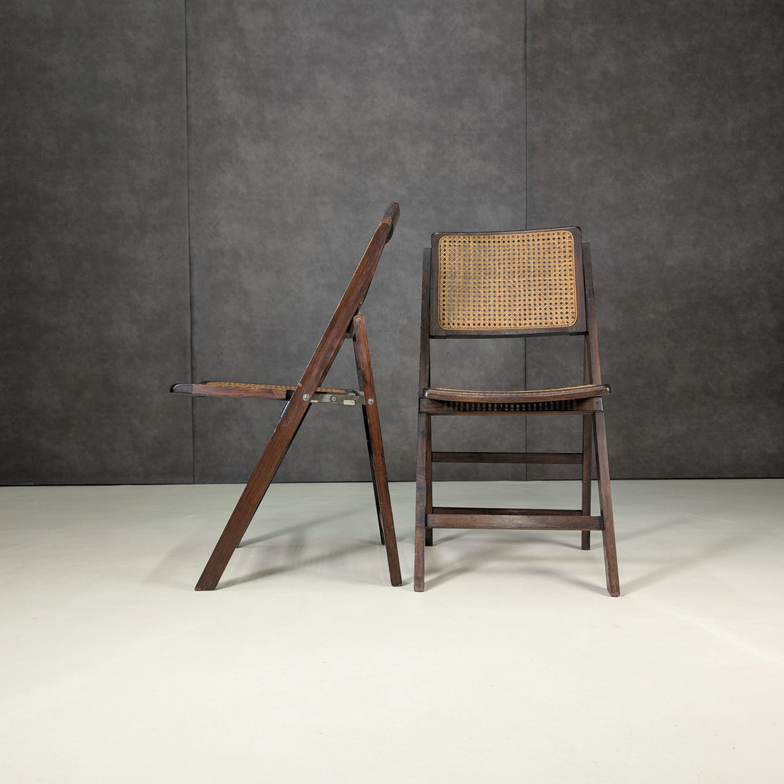 Vintage timber and cane folding chairs demonstrating folding mechanism