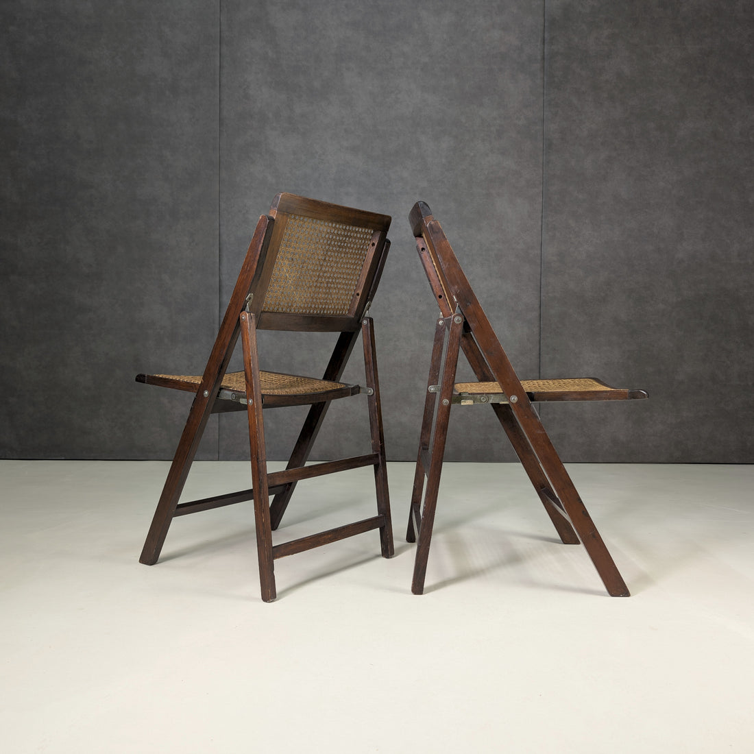 Rear and side profiles of vintage timber and woven cane folding chairs