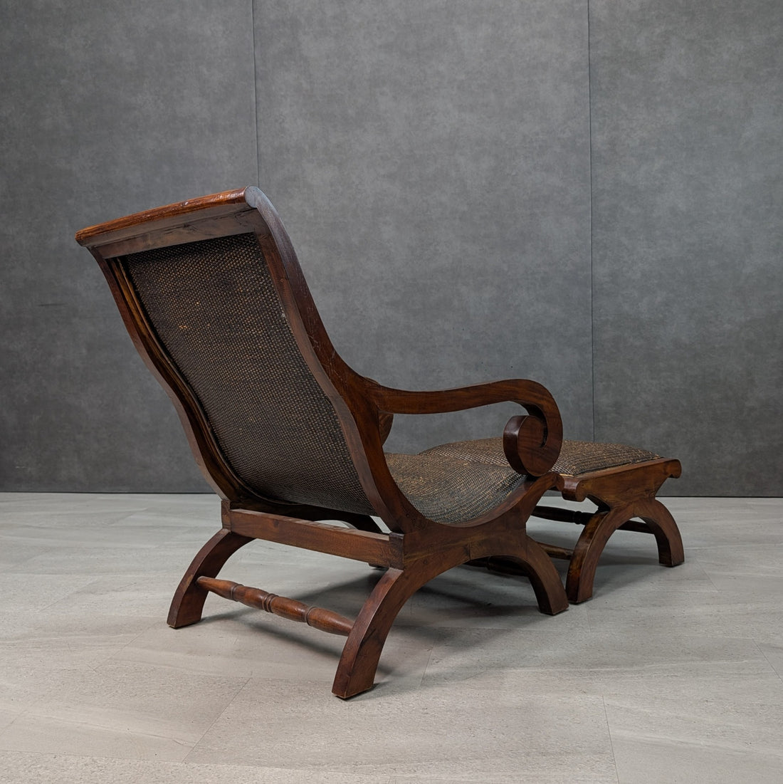 Rear three quarter view of plantation armchair showing the curved timber back frame, woven cane and matching ottoman