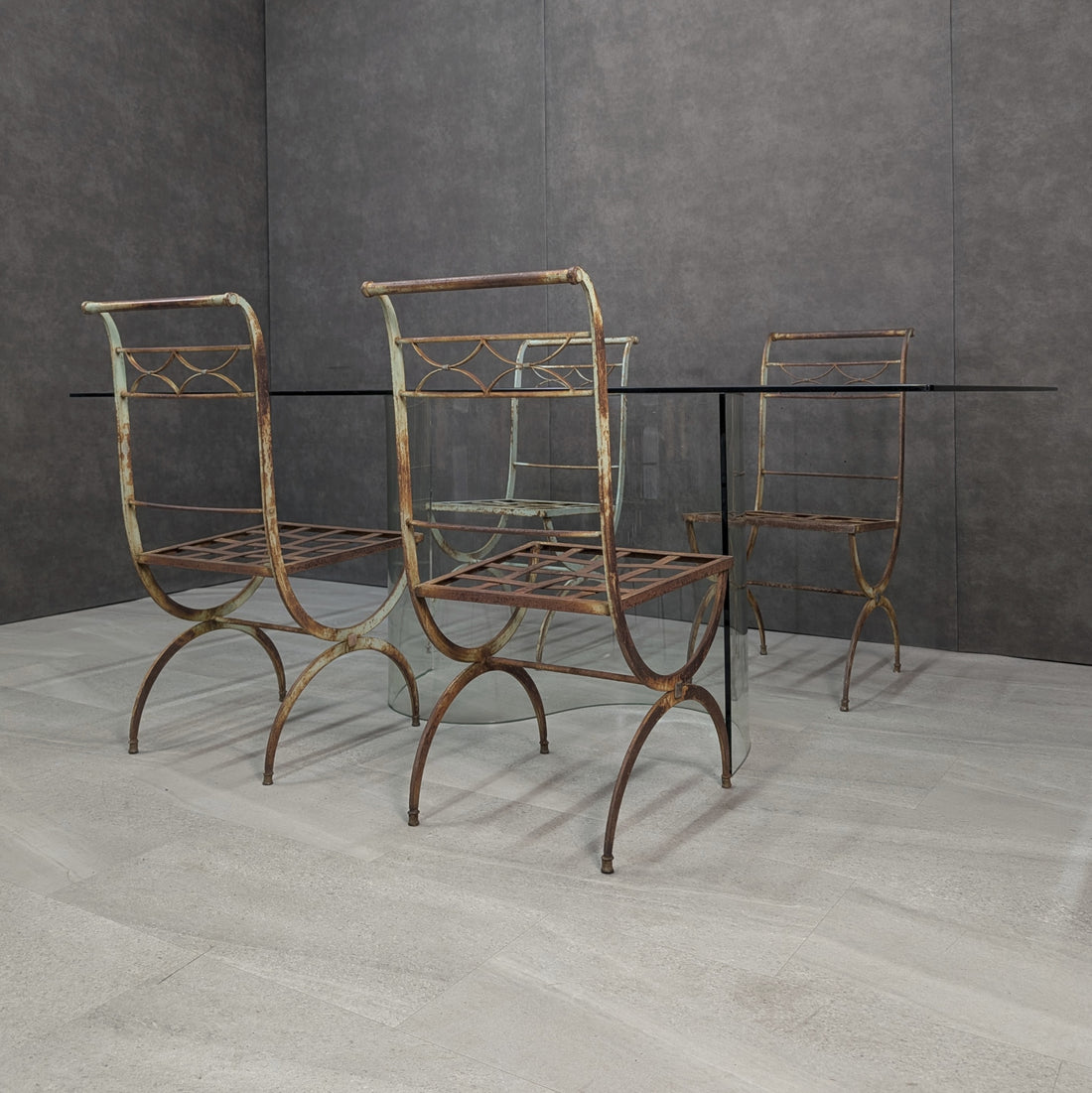 Four French style wrought iron garden chairs with S form clear glass dining table, angled full setting