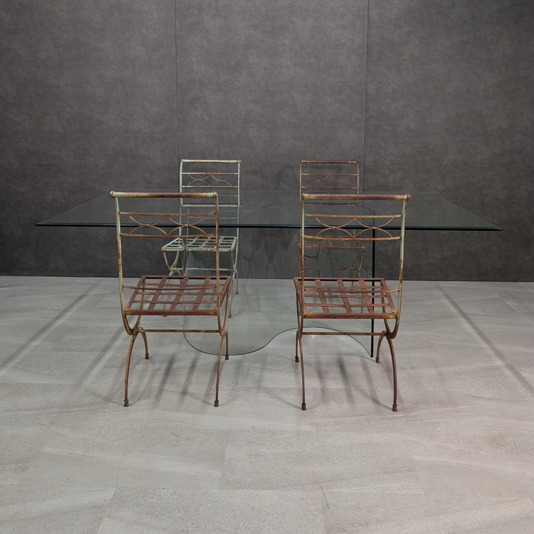 Five piece dining setting with four wrought iron chairs and bevelled glass table, elevated front view